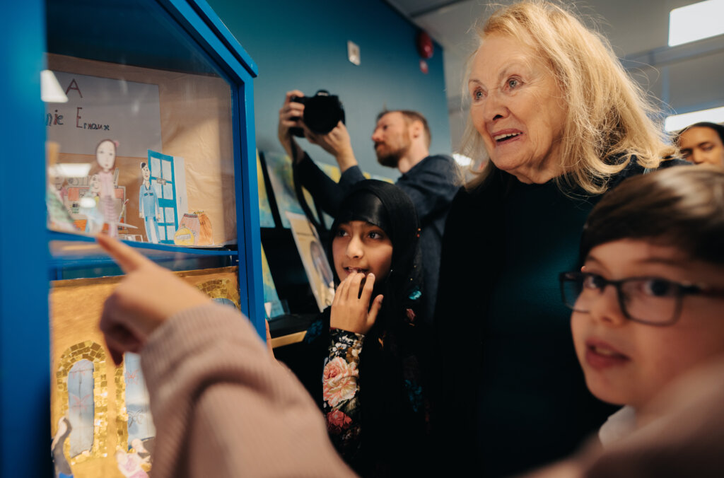 Annie Ernaux looking at a drawing of herself.