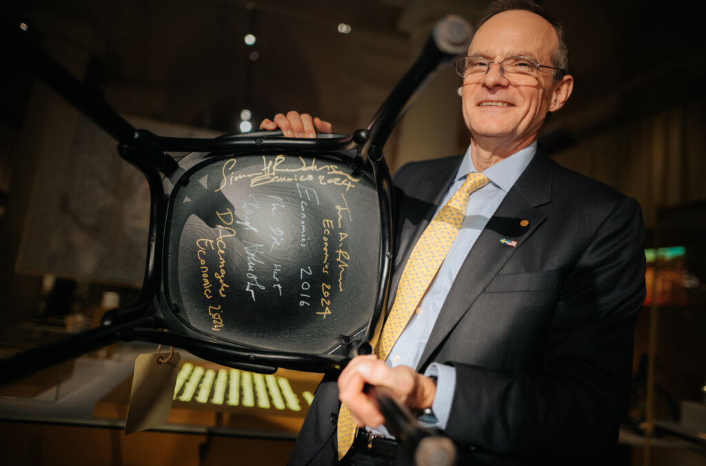 A man showing a signed chair