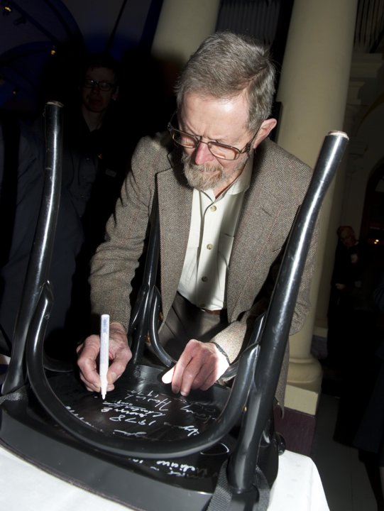 George E. Smith autographs a chair
